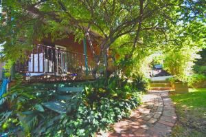 珀斯罗斯莫尔住宿加早餐旅馆的一个带长凳、一棵树和一座房子的花园