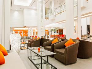 芭堤雅市中心芭提雅宜必思酒店的大堂配有沙发和橙色枕头。