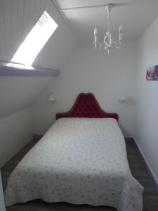 迪耶普Villa D'ALBATRE的一间卧室配有一张带窗户和吊灯的床。