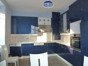迪耶普Villa D'ALBATRE的厨房配有蓝色橱柜和桌椅