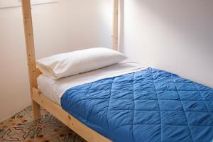 赫罗纳赫罗纳贝德因住宿加早餐旅馆的一张带蓝色棉被和白色枕头的床