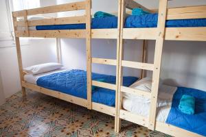 赫罗纳赫罗纳贝德因住宿加早餐旅馆的客房内的双层床配有蓝色双层床