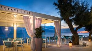 诺维格勒伊斯特拉Rivalmare Boutique Hotel的一间位于海洋前方的带桌椅的餐厅
