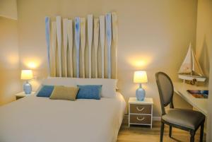 丰沙尔Apartamentos do Mar的卧室配有白色的床和椅子