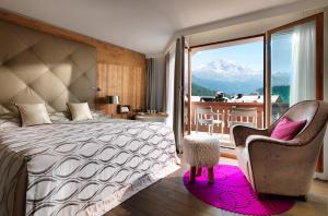 圣莫里茨格堤诺山酒店的一间带一张床和一把椅子的卧室以及一个阳台