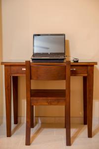 洛雷托Bugambilias Suites的一张坐在木桌边的笔记本电脑