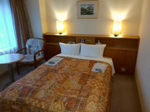 柏崎市柏崎新绿酒店的酒店客房配有一张床铺和一张桌子。