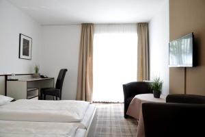 吕贝克阿尼姆斯赫伽尼酒店的酒店客房设有两张床、一张书桌和一个窗户。