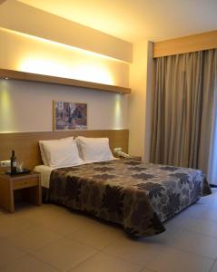 科莫蒂尼凯瑞迪丝酒店的一间卧室配有一张大床、床头柜和一张桌子