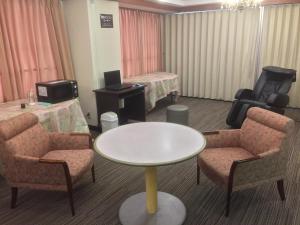 新居滨市新居滨山丘王子酒店的配有桌椅和床的房间