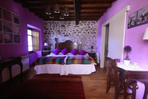 San AciscloOs Tres Teixos的紫色卧室配有一张床和一张桌子