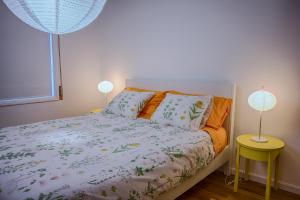 AgudaApeadeiro do Mar的一间卧室配有一张带两盏灯的床。