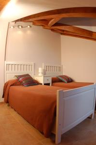 TerminónCasa Rural El Esquilador的一间卧室配有两张带橙色棉被的床
