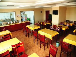 天津格林豪泰天津西青秀川路阳光100的餐厅设有黄色桌子和红色椅子