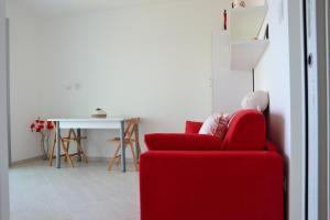 卡斯特尔萨多Miramare Appartamento Roda的客厅配有红色的沙发和桌子