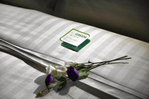 台南文悦旅栈的床上的白色枕头,带紫色的鲜花