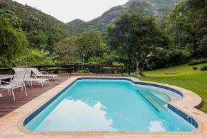 彼得罗波利斯PASSAREDO - Casa de Campo Fazenda Inglesa的一个带桌椅的大型蓝色游泳池