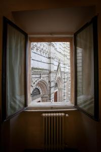 锡耶纳马尼菲科宫殿住宿加早餐旅馆的享有大楼景致的开放式窗户