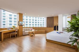胡志明市西贡天堂精品Spa酒店的配有一张床和一张书桌的酒店客房