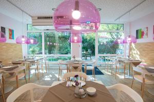 慕尼黑法布酒店的一间带桌椅和粉色灯的餐厅
