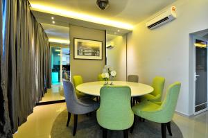 峇都丁宜紫罗兰奢华服务别墅的一间带桌子和绿色椅子的用餐室