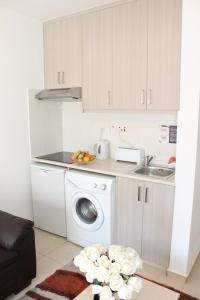 拉纳卡蒂芙尼城市公寓式酒店的厨房配有洗衣机和水槽