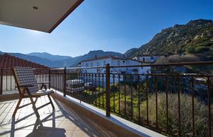 锡基亚Villa Sithonia的椅子坐在阳台上,眺望着群山