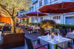 布雷根茨德国酒店的一间带桌椅和遮阳伞的餐厅
