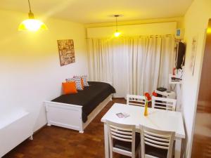 门多萨Departamento Temporario Céntrico Mendoza的小房间设有一张床、一张桌子和椅子