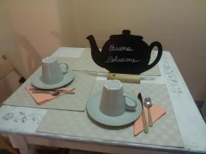 蒙特卡蒂尼泰尔梅吉尔迪穆拉旅馆的一张带两顶帽子和茶壶的桌子