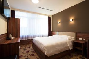 阿姆斯特丹金斯考特酒店的一间卧室设有一张大床和一个窗户。