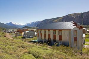 厄尔查尔坦Hosteria Alma de Patagonia的山丘上以山为背景的房子