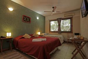 门多萨Hotel Xumec Mendoza的一间卧室配有一张带红色毯子的床和窗户。