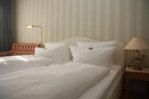 提努姆克里斯廷森酒店的白色的床、白色枕头和红色椅子