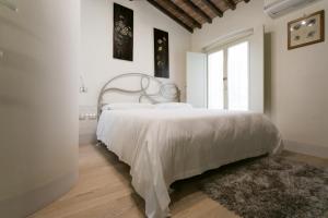 比萨Relais Pacinotti Apartments的白色的卧室设有一张大床和一个窗户