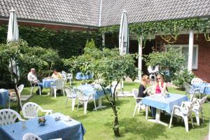 吕贝克祖姆拉兹赫恩酒店的一群坐在花园里桌子上的人
