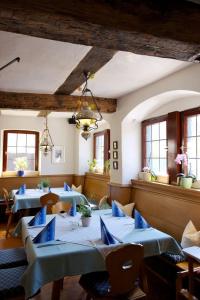 Tauberzell祖姆法尔肯兰德豪斯酒店的餐厅设有蓝色的桌椅和窗户。