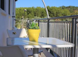 利多康奇耶Appartamento La Vela的阳台上的桌椅,种植了盆栽植物