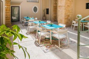 特拉帕尼Hotel San Michele的庭院里一排蓝色的桌椅