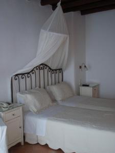 图罗斯帕拉迪森酒店的一间卧室配有一张带天蓬的白色床