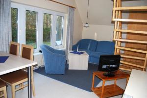 维特Doppelhaushälfte in Vitte auf Hiddensee的客厅配有蓝色的沙发和桌子