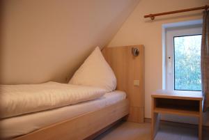 维特Doppelhaushälfte in Vitte auf Hiddensee的一间卧室配有一张带枕头的床