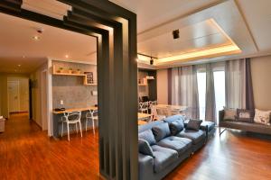 釜山南浦休闲旅馆的一间带蓝色沙发的客厅和一间厨房