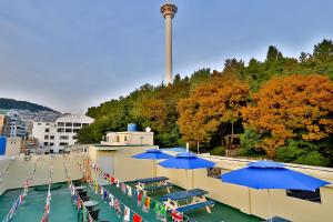 釜山南浦休闲旅馆的一组桌子和蓝色伞在一座建筑里