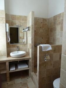 圣雷米普罗旺斯科斯特艾尔皮酒店的一间带水槽和镜子的浴室