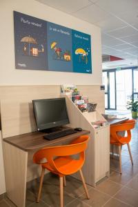 凯恩艾斯卡恩诺德麦莫瑞欧酒店的办公室设有一张桌子、一台电脑和橙色椅子