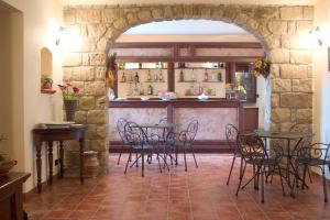 波利齐杰内罗萨Il Baglio di Nonna Clelia的餐厅的拱门,配有桌椅