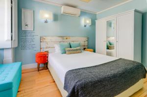 里斯本卡萨斯·拜萨 - 朱丽思和马德琳酒店的一间卧室设有一张大床和蓝色的墙壁