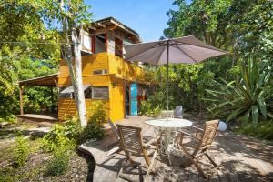 圣弗朗索瓦智慧加勒比度假屋的黄色的房子,配有桌椅和雨伞