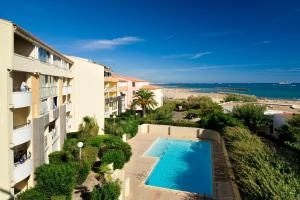 阿格德角Vacancéole - Savanna Beach- Terrasses de Savanna的一座公寓,毗邻一座建筑,设有游泳池